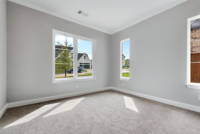 spare room featuring baseboards, crown molding, visible vents, and carpet