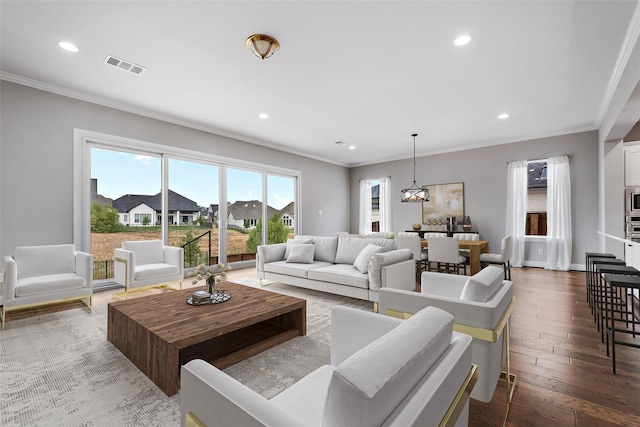 living area featuring visible vents, recessed lighting, ornamental molding, and wood-type flooring