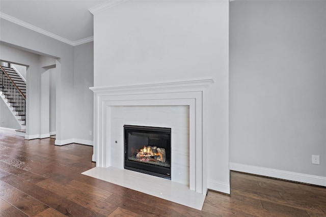 room details featuring a fireplace with flush hearth, wood finished floors, crown molding, and baseboards