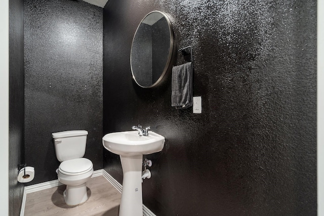 4652 Raleigh Dalton Rd, Dallas, TX 75227 - bathroom with wood finished floors, toilet, baseboards, and a sink