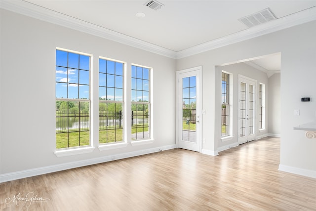 unfurnished room featuring light wood-style flooring, visible vents, and a water view