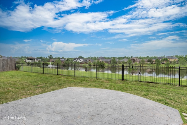 view of patio with a gate, fence, a water view, and a residential view