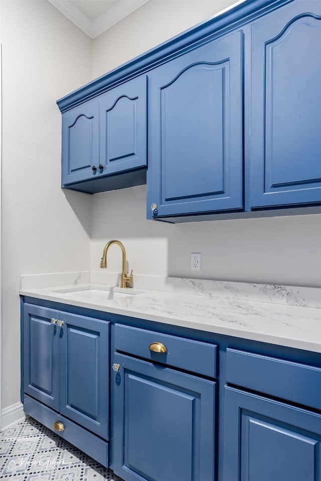 interior space with baseboards, a sink, and ornamental molding