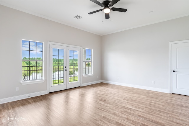 unfurnished room featuring light wood-style floors, visible vents, crown molding, and a healthy amount of sunlight