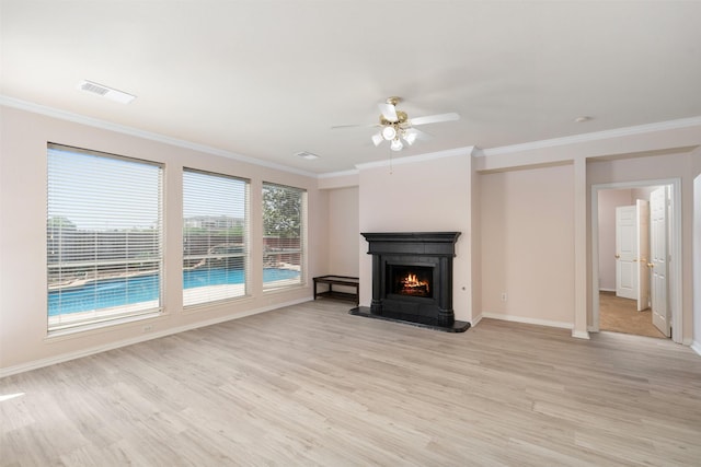 unfurnished living room with a warm lit fireplace, visible vents, a ceiling fan, light wood-style floors, and crown molding