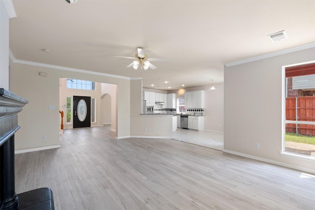 unfurnished living room featuring ceiling fan, ornamental molding, visible vents, and light wood-style flooring