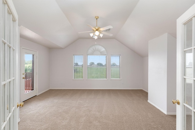 additional living space with lofted ceiling, baseboards, a ceiling fan, and light colored carpet
