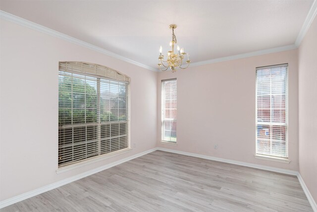 unfurnished room featuring crown molding, an inviting chandelier, light wood-type flooring, and a healthy amount of sunlight