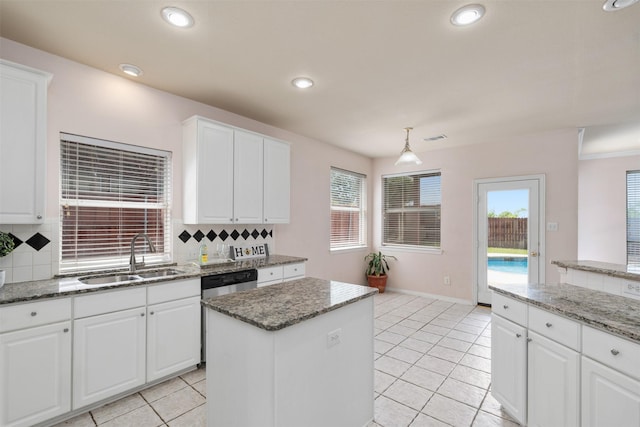 kitchen featuring plenty of natural light, backsplash, a sink, and a kitchen island