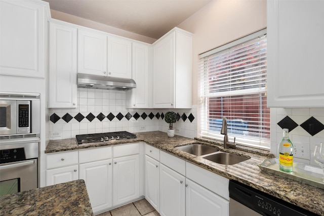 kitchen featuring a sink, white cabinetry, decorative backsplash, under cabinet range hood, and appliances with stainless steel finishes