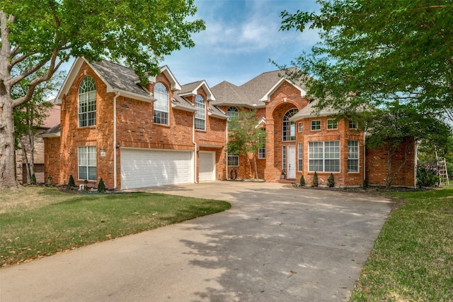 909 Hills Creek Dr, Mckinney, TX 75072 - view of front of home with a garage, driveway, a front yard, and brick siding