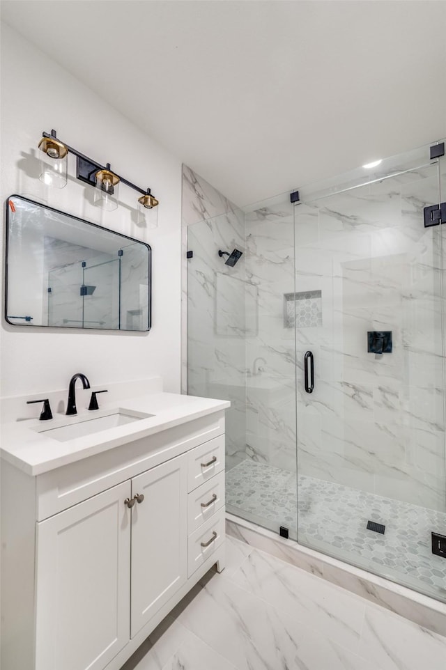 bathroom with a marble finish shower, vanity, and marble finish floor