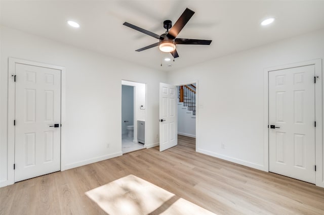 unfurnished bedroom featuring baseboards, recessed lighting, ensuite bath, and light wood-style flooring