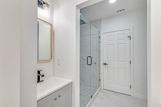 bathroom with visible vents, a marble finish shower, vanity, and marble finish floor