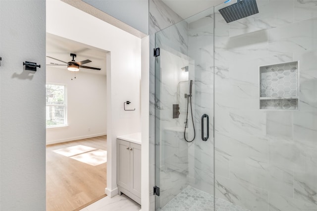 bathroom with baseboards, a ceiling fan, and a marble finish shower