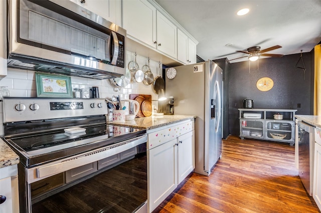 5601 Jane Anne St, Haltom City, TX 76117 - kitchen with white cabinets, stainless steel appliances, wood finished floors, a ceiling fan, and decorative backsplash