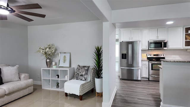 2904 Chestnut Ave, Fort Worth, TX 76106 - kitchen with stainless steel appliances, open floor plan, white cabinetry, backsplash, and ceiling fan