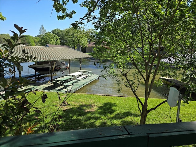 view of dock featuring a lawn, boat lift, and a water view