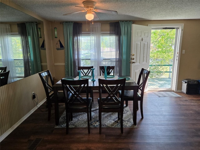 dining space with wood finished floors, visible vents, baseboards, a textured ceiling, and ceiling fan