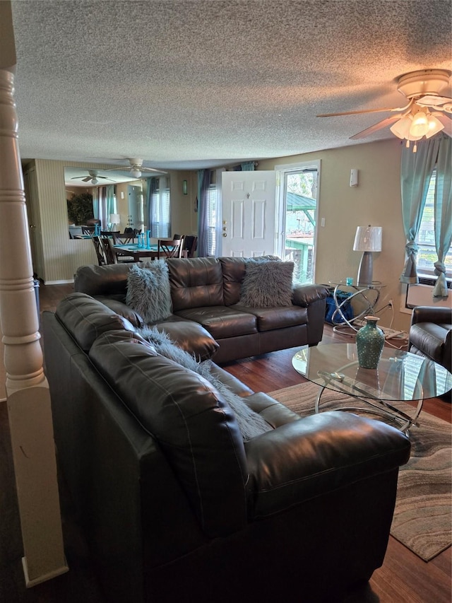 living room featuring wood finished floors, a textured ceiling, and ceiling fan