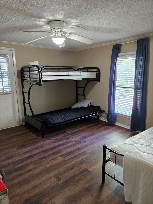 bedroom with crown molding, wood finished floors, multiple windows, and a textured ceiling