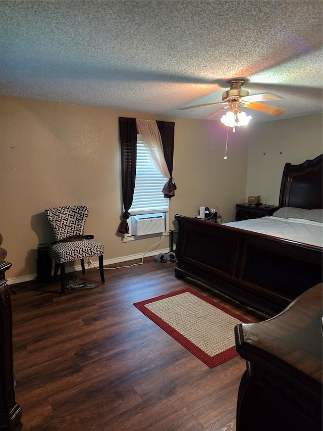 bedroom with a textured ceiling, cooling unit, baseboards, a ceiling fan, and wood finished floors