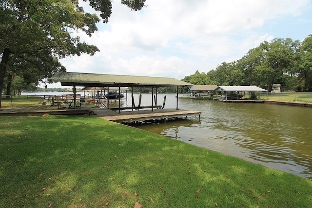 view of dock featuring a lawn, a water view, and boat lift