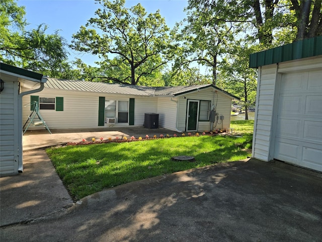 rear view of property with a yard and a garage