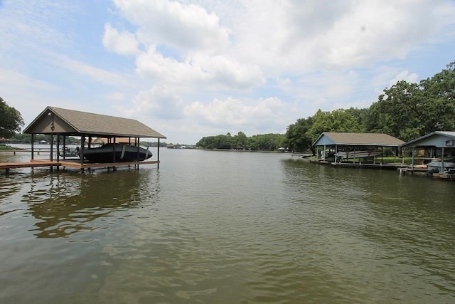dock area featuring boat lift and a water view