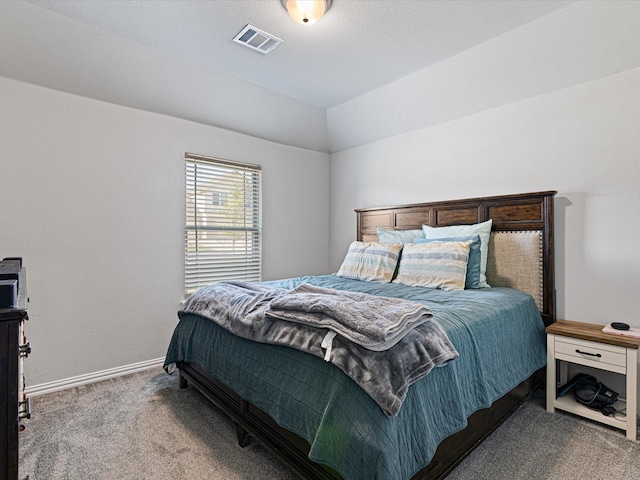 carpeted bedroom featuring baseboards, vaulted ceiling, and visible vents