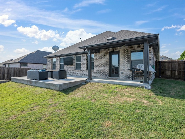 rear view of property with a fenced backyard, brick siding, a yard, and a patio