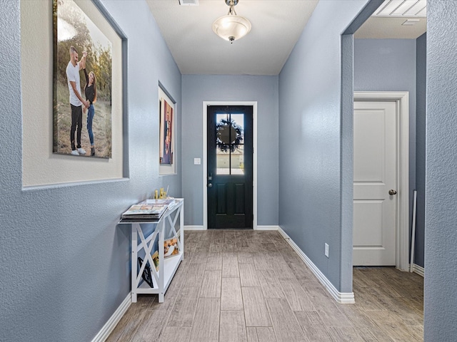 entrance foyer with a textured wall and wood finished floors
