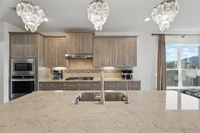 14329 Home Trl, Fort Worth, TX 76262 - kitchen with light stone countertops, a sink, appliances with stainless steel finishes, and a chandelier