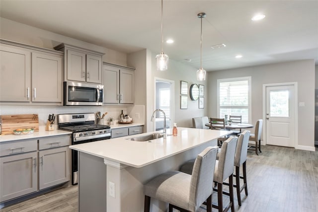 kitchen featuring stainless steel appliances, a sink, recessed lighting, and gray cabinets