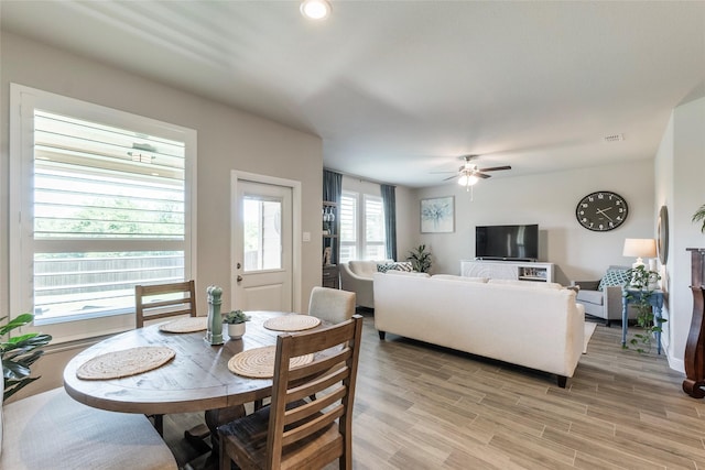 dining area with a ceiling fan and light wood-style floors