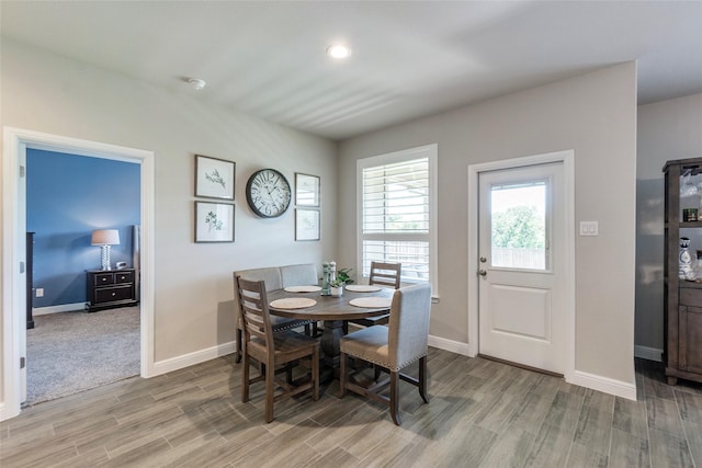 dining area with baseboards and light wood-type flooring