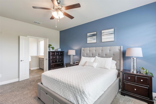 bedroom with carpet, visible vents, ensuite bath, baseboards, and ceiling fan
