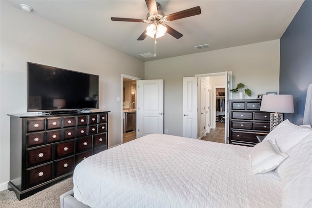 bedroom featuring baseboards, ensuite bath, visible vents, and ceiling fan