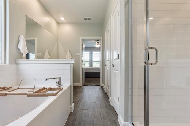 full bath with wood finished floors, a garden tub, visible vents, and a stall shower