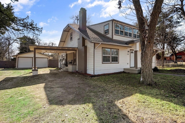 view of front of property with fence, an outdoor structure, a chimney, and a front yard