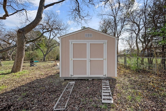 view of shed featuring fence