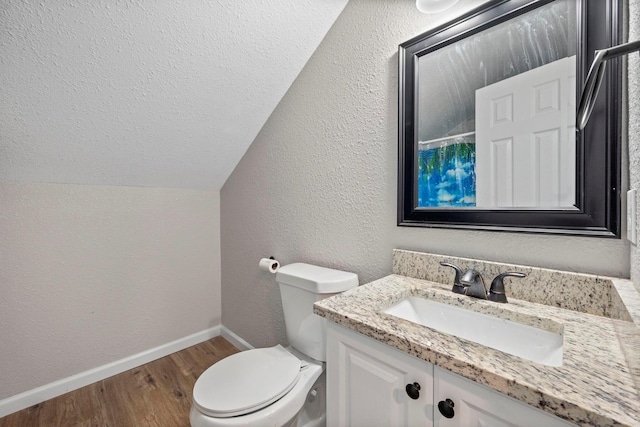 full bathroom with toilet, vaulted ceiling, baseboards, wood finished floors, and vanity