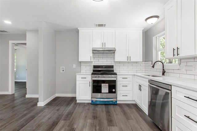4227 Harvey Dr, Mesquite, TX 75150 - kitchen featuring appliances with stainless steel finishes, under cabinet range hood, a sink, backsplash, and white cabinetry