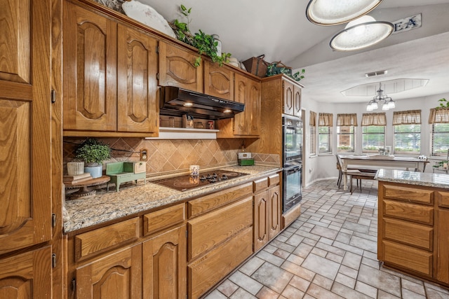 kitchen with black appliances, decorative backsplash, brown cabinets, under cabinet range hood, and visible vents