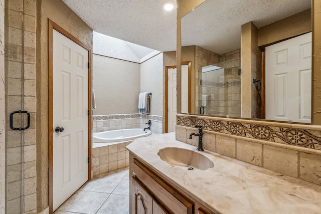 full bathroom featuring a garden tub, tile patterned floors, a textured ceiling, a stall shower, and vanity