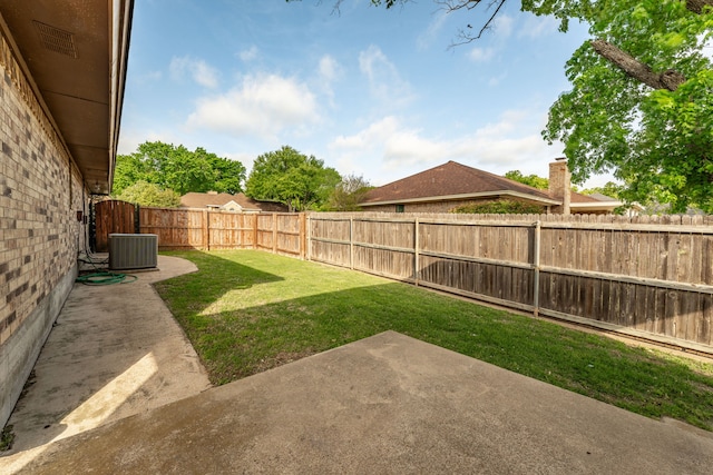 view of yard featuring a fenced backyard, a patio area, and central AC