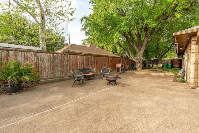 view of patio featuring a fenced backyard and a fire pit