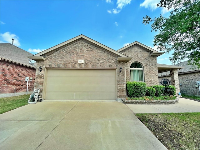 single story home featuring an attached garage, driveway, and brick siding
