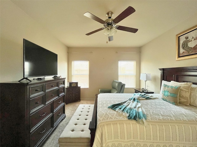 bedroom with ceiling fan, light colored carpet, and multiple windows