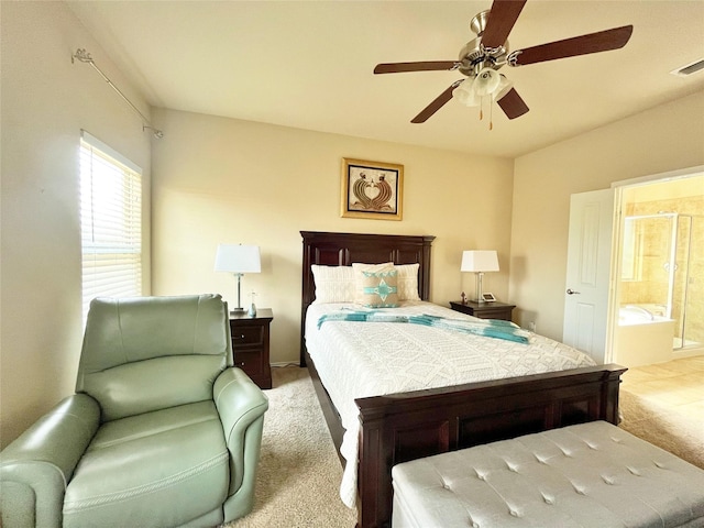 bedroom with ensuite bathroom, visible vents, carpet floors, and a ceiling fan